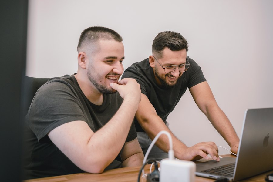 Two colleagues working through something on a laptop