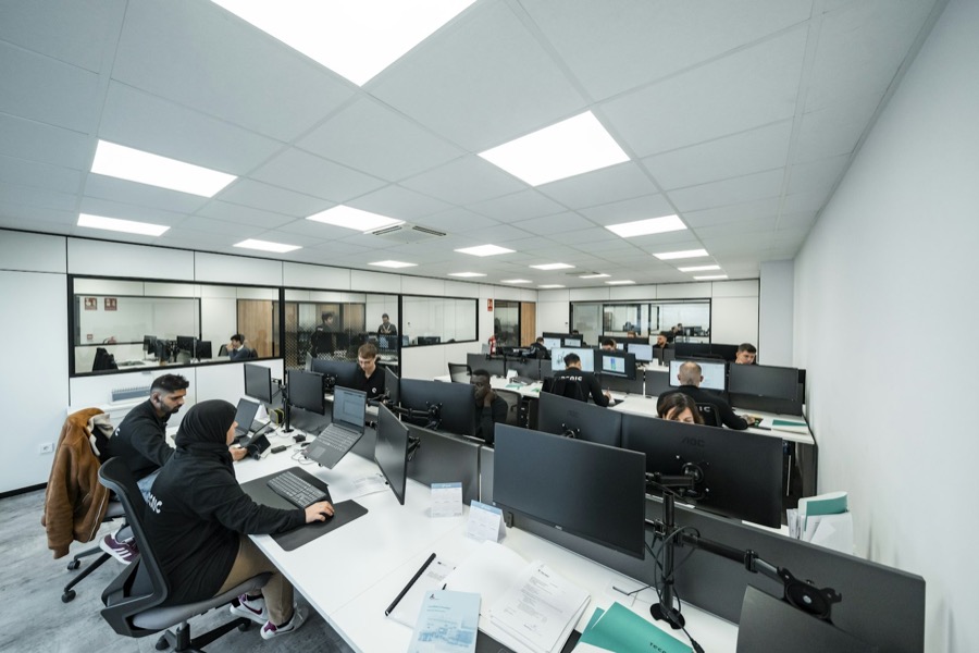 A bright open office with people working at computer monitors